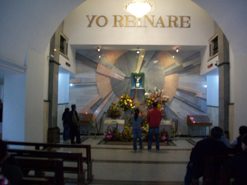 The statue is no more than two feet high, in a glass case mounted on the wall behind the altar